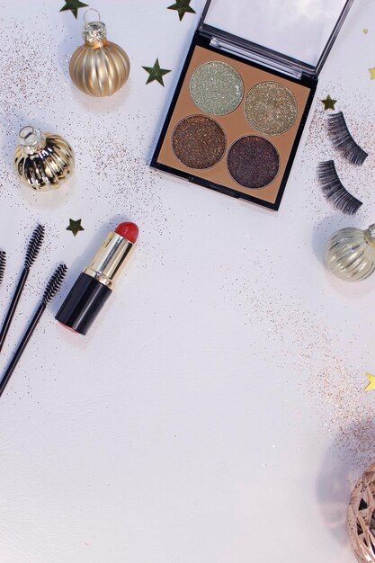 Flat lay composition with makeup products and christmas decor on white background. template for design, top view flat lay copy space.