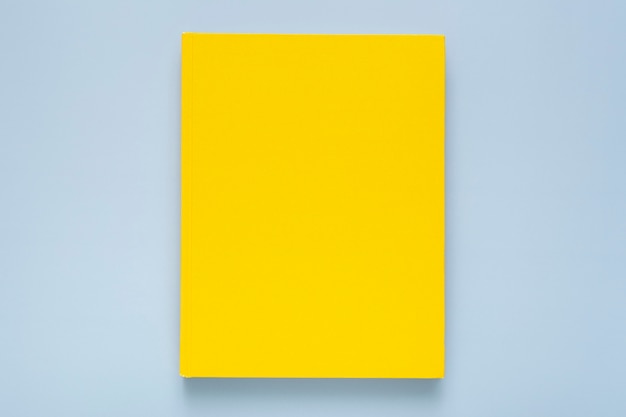 Flat lay composition with yellow notebook on blue background