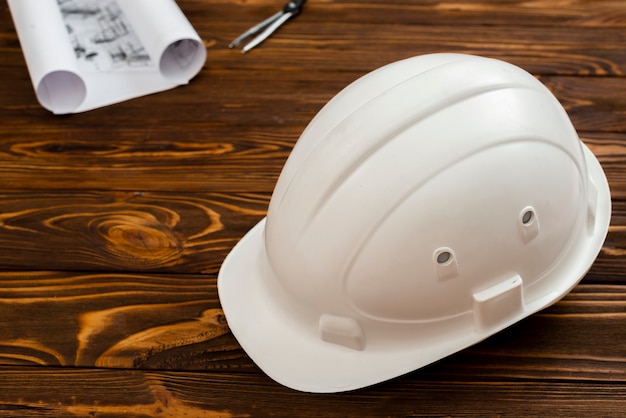 Flat-lay construction helmet with plans in background