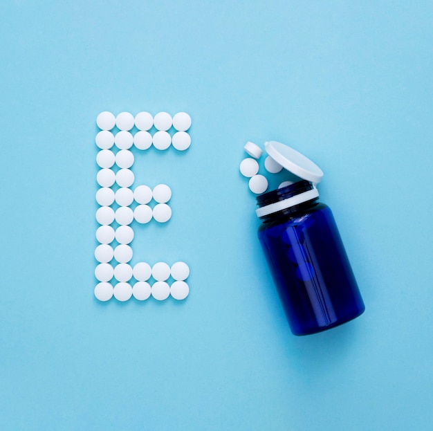 Flat lay of container with pills spelling letter e