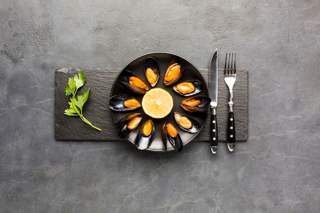 Flat-lay cooked mussels plate on slate