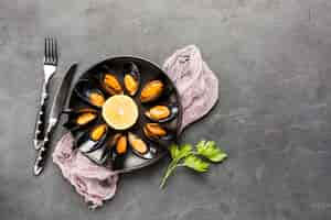 Free photo flat-lay cooked mussels plate with cutlery