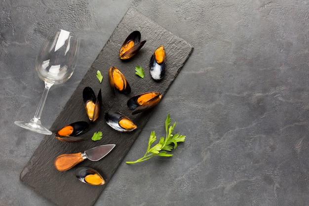 Flat-lay cooked mussels on slate with copyspace