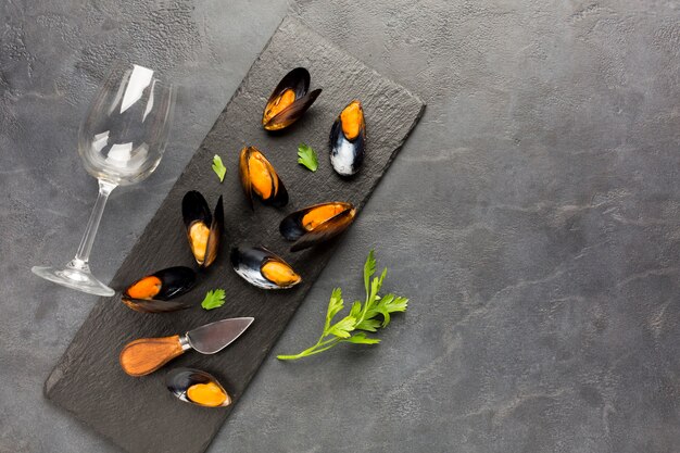 Flat-lay cooked mussels on slate with copyspace