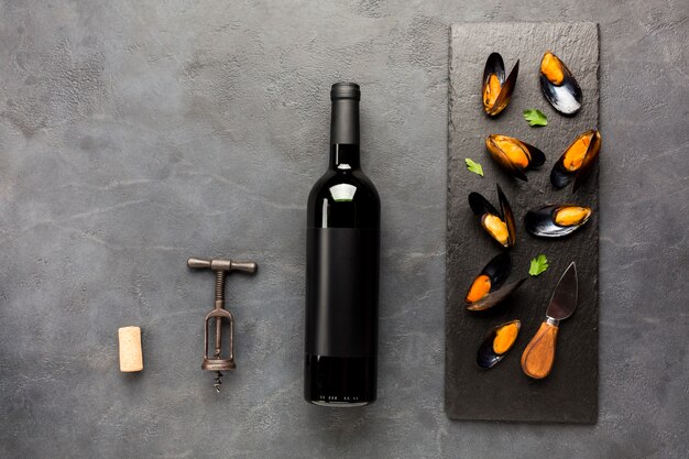 ワインの瓶とスレートの平らな調理ムール貝