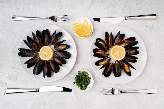 Free photo flat lay cooked mussels with cutlery