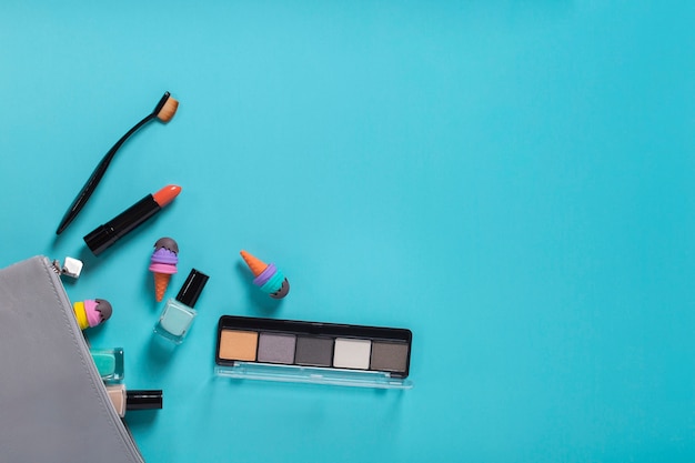 Flat lay of cosmetic accessories on blue background with copy space