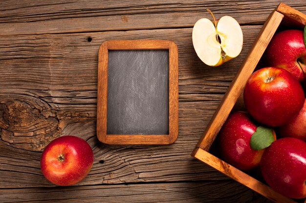 Flat-lay crate with ripe apples with blackboard