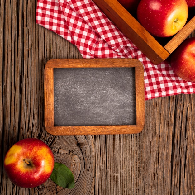 Free photo flat-lay crate with ripe apples with blackboard