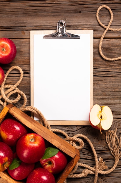 Flat-lay crate with ripe apples with clipboard