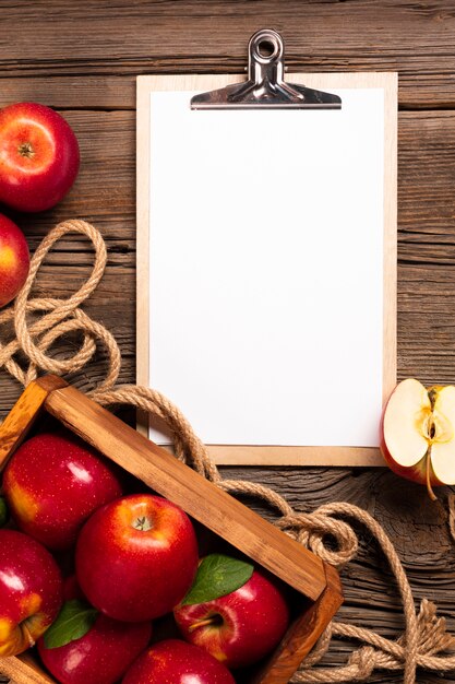 Flat-lay crate with ripe apples with clipboard