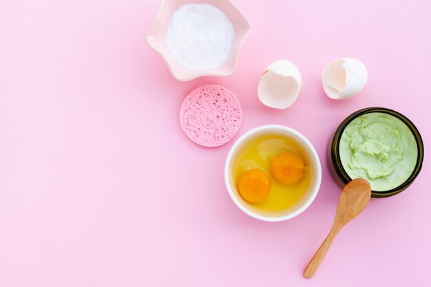 Flat lay of cream and eggs on pink bacground with copy space