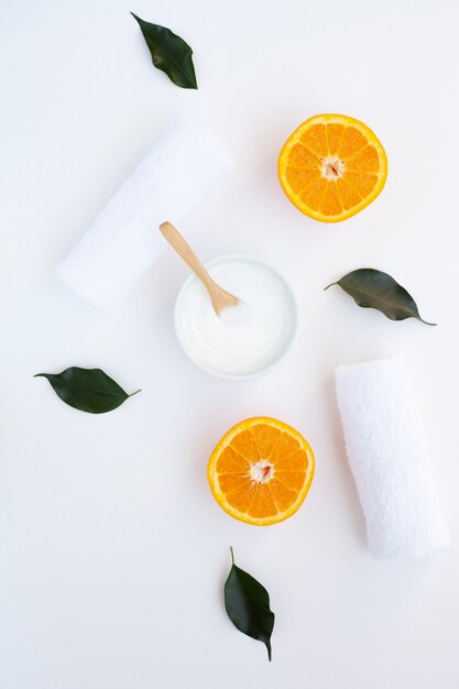 Flat lay of cream and orange slices on white background