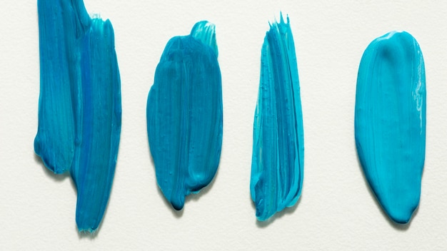 Flat lay of creative blue paint brush strokes on surface