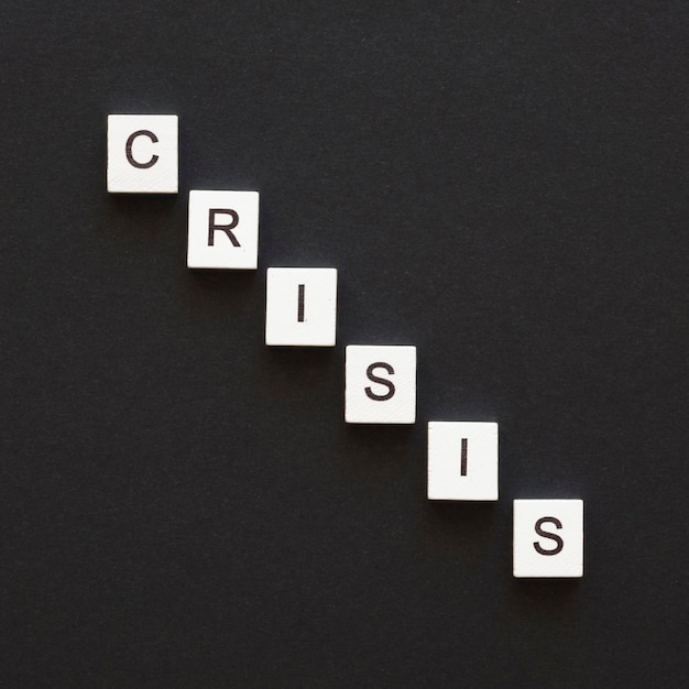 Flat lay crisis word written on wooden cubes