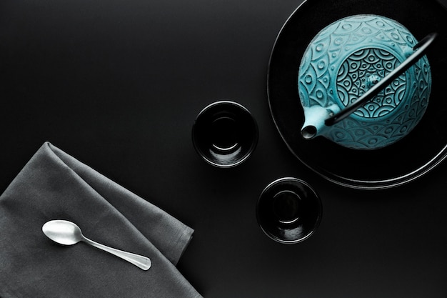 Flat lay of crockery with teapot and silver spoon