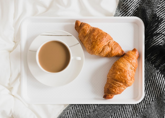 Flat lay croissants and coffee on tray