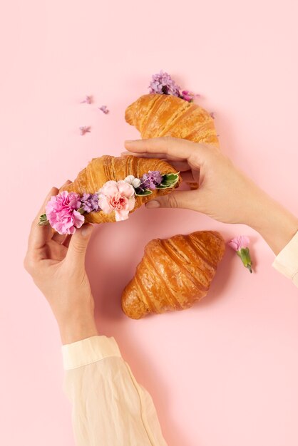 Flat lay croissants and flowers arrangement