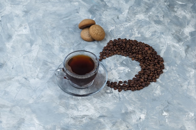 Flat lay cup of coffee, cookies with coffee beans on light blue marble background. horizontal