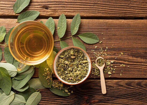 Flat lay cup of tea and natural herbs leaves