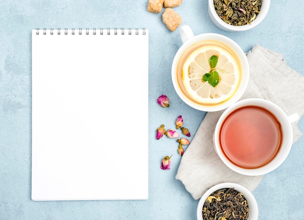 Flat lay cups with tea and notebook