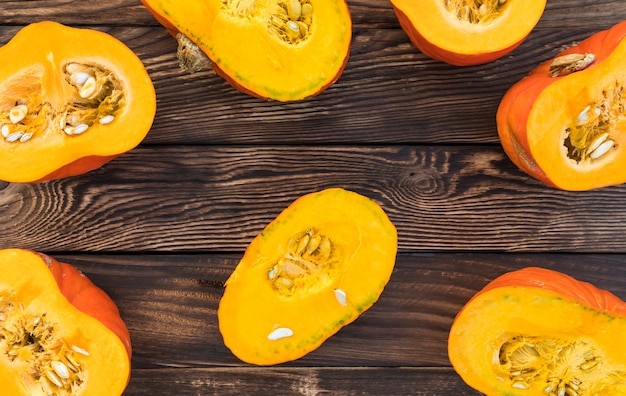 Flat lay cut pumpkins on wooden background