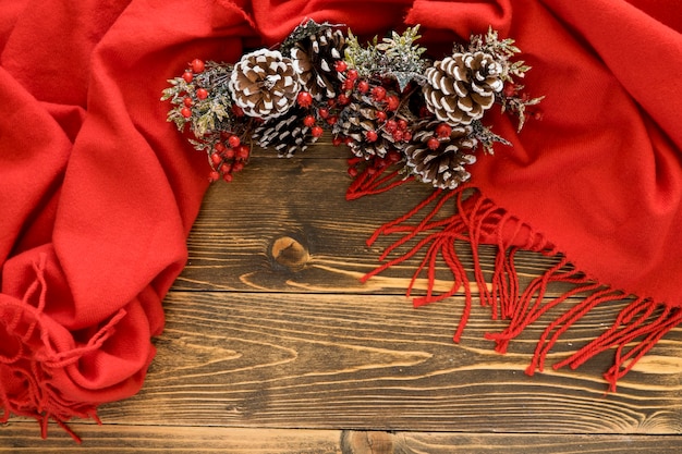 Flat lay cute winter pine cones on red scarf