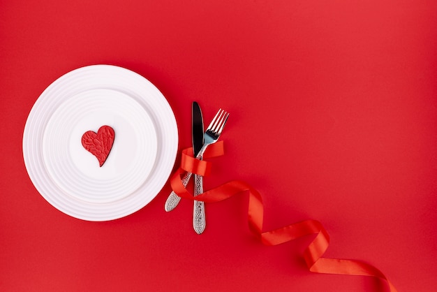 Free photo flat lay of cutlery with heart on plate and copy space