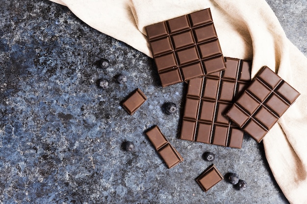 Flat lay dark chocolate on cloth with blueberries