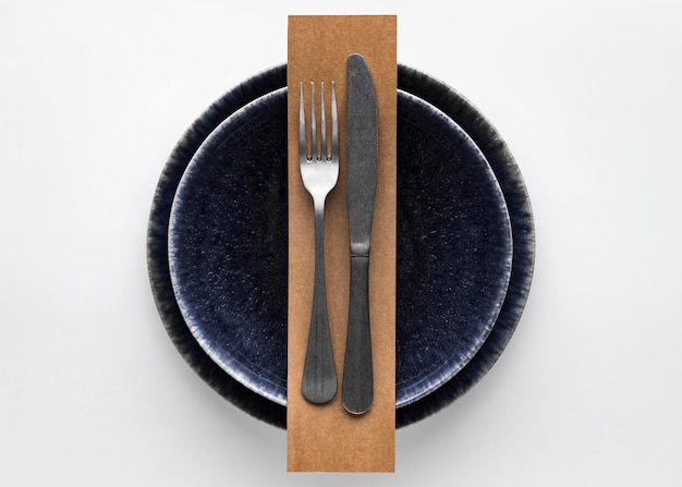 Free photo flat lay of dark dinnerware with  fork and knife