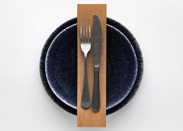 Flat lay of dark dinnerware with  fork and knife