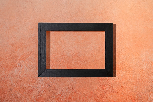 Flat lay dark frame on orange background