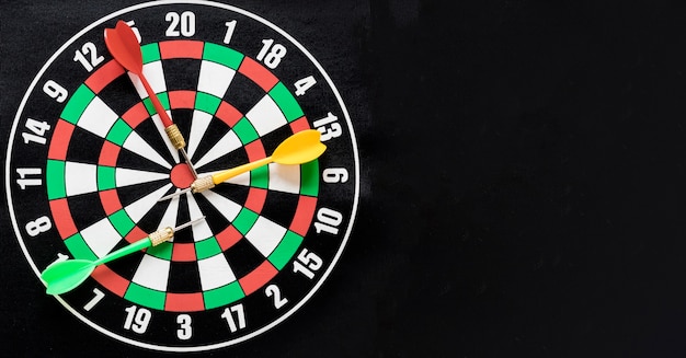 Free photo flat lay darts table on black background with copy space