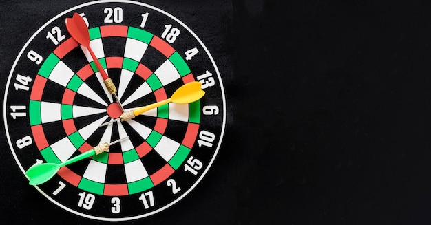 Flat lay darts table on black background with copy space