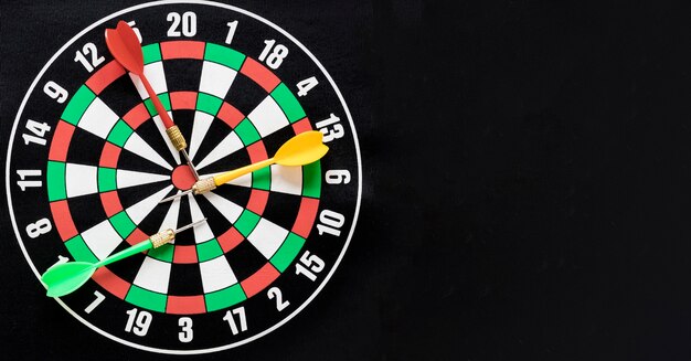 Flat lay darts table on black background with copy space