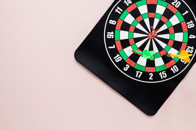 Flat lay darts table on pink background with copy space