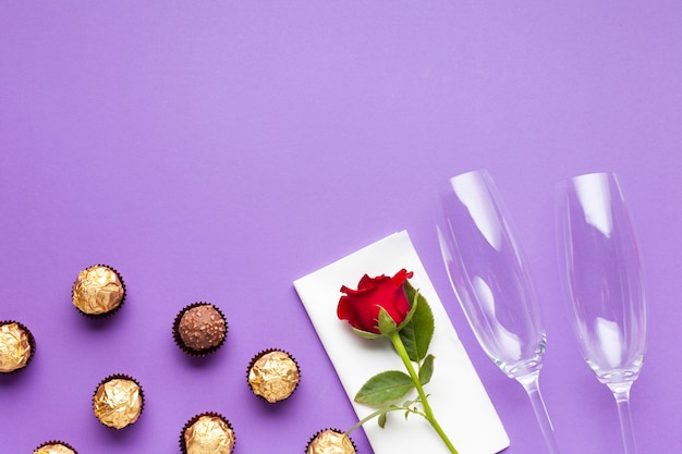 Flat lay decoration with chocolate balls and red rose