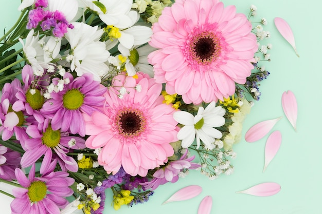 Flat lay decoration with flowers on green background