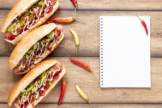 Flat lay decoration with hot dogs and peppers