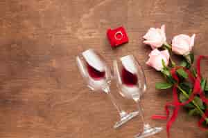 Free photo flat lay decoration with roses, wine and ring