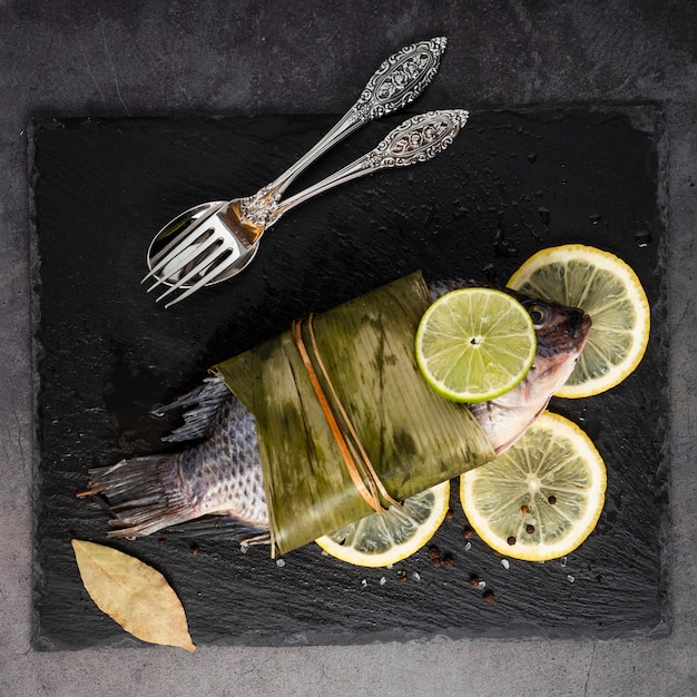 Flat lay decoration with tasty fish and lemons