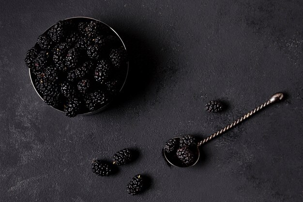 Flat lay delicious blackberries in minimalist bowl