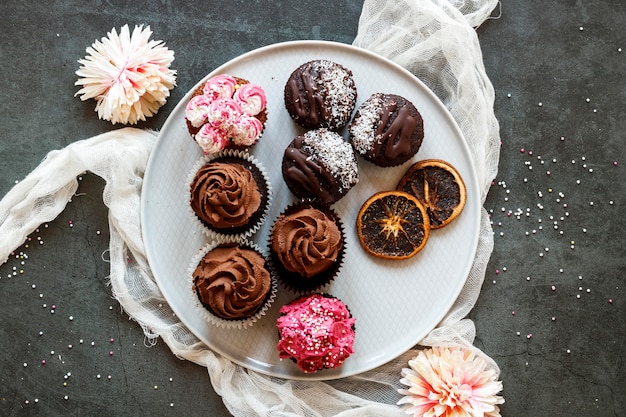 Foto gratuita piatto di laici deliziosi cupcakes concetto