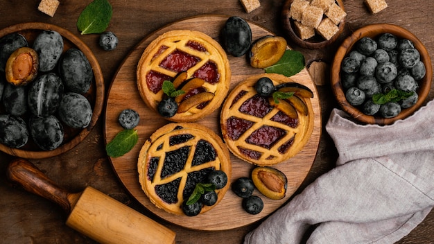 Flat lay of delicious fruit pies with plums