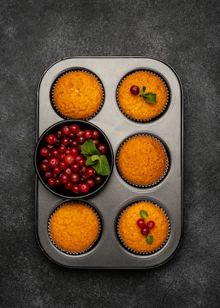 Foto gratuita lay piatto di deliziosi muffin con frutti di bosco in padella