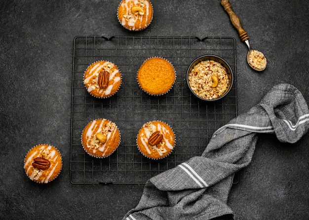 Flat lay of delicious muffins with nuts on cooling rack