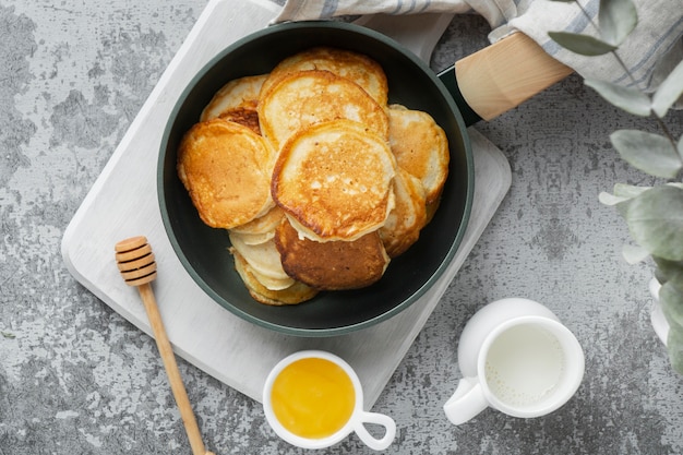 Flat lay delicious pancakes and honey