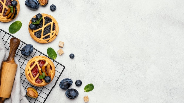 Free photo flat lay of delicious pies with fruits and copy space