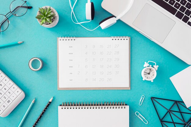 Flat lay desk calendar on blue background