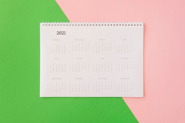 Flat lay desk calendar on coloured background